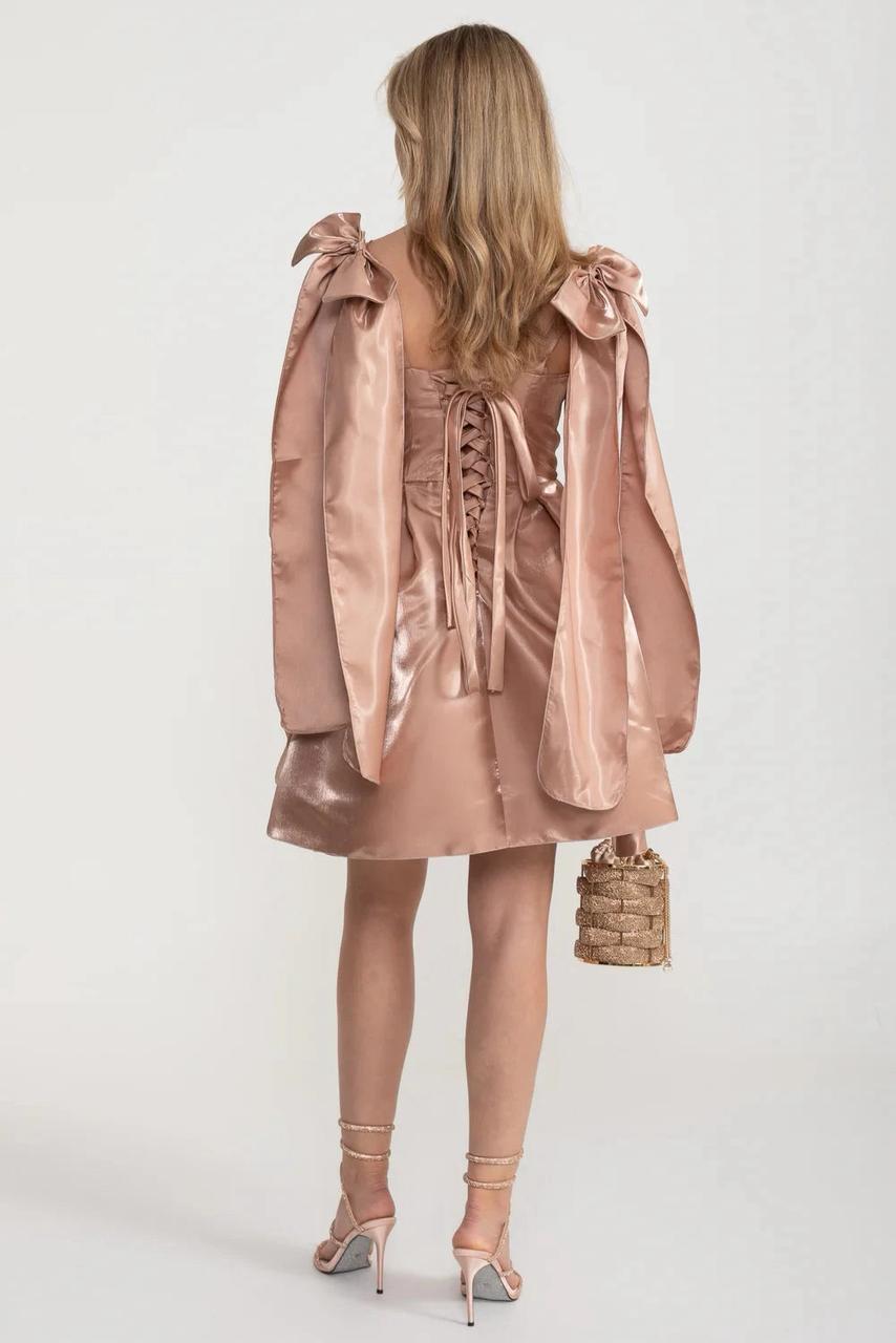 فستان قصير من الساتان بلون وردي فاتح مزين بفيونكات على الكتفين